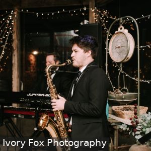 Emile Ryjoch playing saxophone and Jonathan Ruse playing keyboards and Natalie Cruse playing drums at a wedding at White Hill Estate in Adelaide South Australia on 20th October 2018